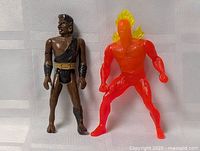 Human Torch and brown warrior action figures standing upright