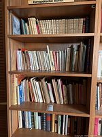 Three wooden shelves filled with German books