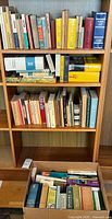 Entire bookshelf section with three shelves and a box containing numerous language books