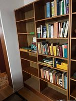 Full view of brown wood veneer bookcase showing multiple shelves