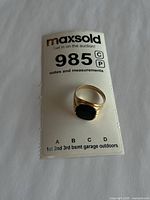 Ring on identification card showing overall form and gemstone