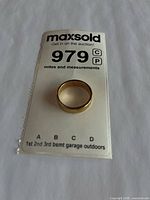 Gold wedding band on MaxSold lot card