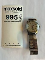 Front view of Helvetia wristwatch beside lot card