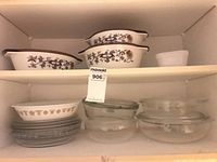 Overall cabinet view showing casseroles, Corelle bowl, pie plates, glass bowls