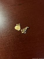 Both gold pendants on tabletop