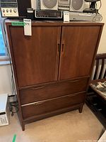 Front view of tall dresser armoire showing two-door cabinet and two drawers