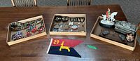 Overview of three trays and pennant with figurine, tanks, medals, buttons