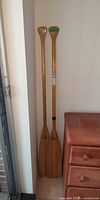 Pair of wooden canoe paddles leaning against wall