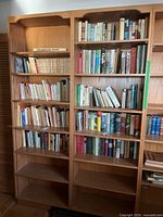 Full view of both matching veneer bookshelves filled with books