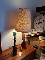 Tall teak lamp with shade and shorter lamp base visible
