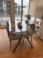 Full view of glass top table with four chairs arranged around it