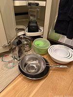 Group shot of blender, bowls, pans, tools on floor