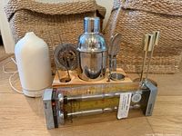 Lot overview showing diffuser, bar tool set, beer chillers package, two seagrass baskets and two metal candlesticks