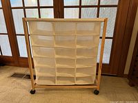 Front view of organizer showing 20 canvas cubbies in wood frame on casters