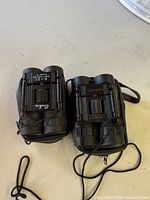 Top view of both folded binoculars showing brand names and cases