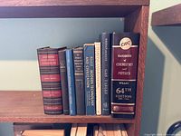 Shelf with eight hardcover reference books as listed