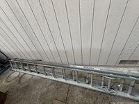 Full length view of metal extension ladder on ground