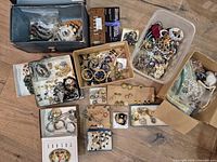 overview of all containers of costume jewellery spread on floor