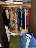 Closet view showing full assortment of vintage women’s outerwear and garments on hangers