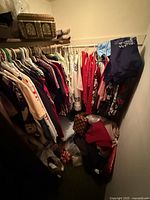 Closet overview showing hanging vintage clothing and items on floor and shelf