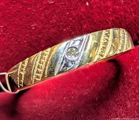 Ring profile showing textured yellow gold band and diamond accent