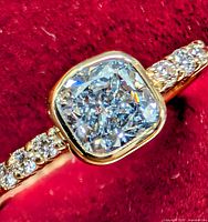 Close-up of bezel-set blue lab diamond with accent stones on band