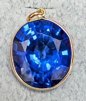 Front view of oval royal blue lab sapphire pendant in 10K gold