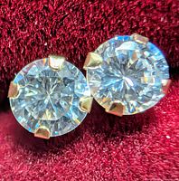 Close-up of both round CZ studs in gold prong settings
