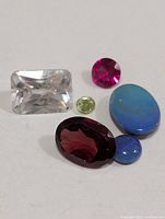 Assorted loose gemstones arranged on white background