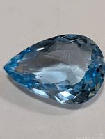 Pear-cut blue topaz gemstone front view displaying facets and color