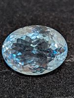 Top view of oval blue topaz gemstone on dark background