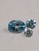 Three loose faceted zircons, one oval blue, two small round