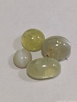 Close-up of four cat's eye cabochon stones showing color and clarity