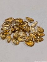 Loose pear-shaped citrine gemstones spread on surface