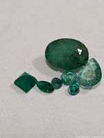 Assorted faceted emeralds close-up showing shapes and colour