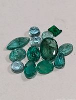 Group of faceted emeralds showing variety of cuts and colors