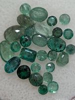 Group of loose emerald gemstones assorted cuts and sizes