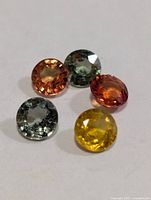 Five round faceted sapphires various colours