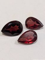 Three pear-shaped faceted garnets close-up on white background
