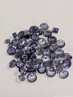 Group of small faceted iolite stones showing color and cuts
