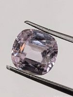 Front view of cushion-cut Kunzite held by tweezers