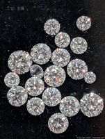Cluster of 18 loose round brilliant diamonds on black background