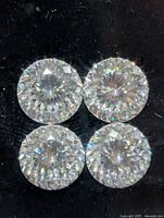 Close-up of four round brilliant cut moissanite stones