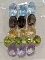 All 15 gemstones laid out, showing colour variety and cuts