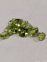 Loose peridot gemstones grouped on white surface