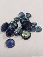 Cluster of loose faceted blue and green sapphire stones