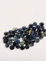Group of small round blue to blue-green faceted sapphires
