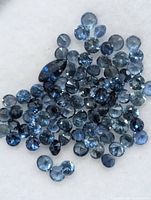 Close-up of pile of small blue sapphires on white background