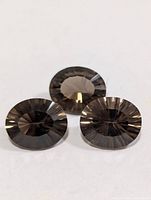 Three oval smokey quartz gemstones on white background