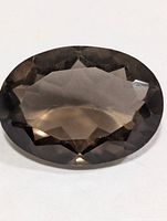 Top view of oval faceted smokey quartz showing color and facet pattern